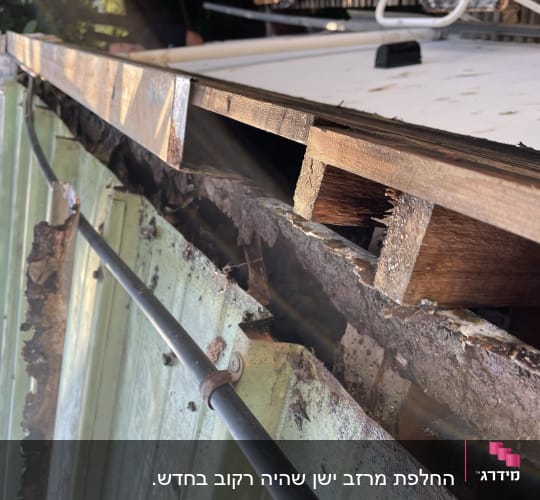 גג מתכת עם נזקי חלודה ועץ חשוף